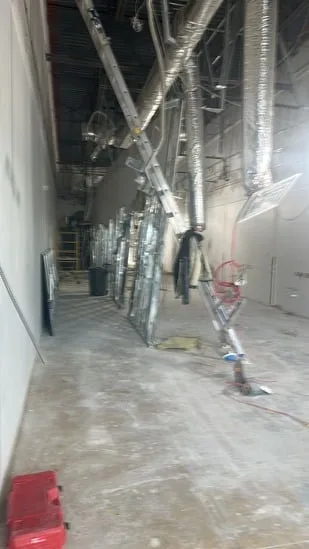 Commercial interior renovation with exposed ductwork and wall framing.